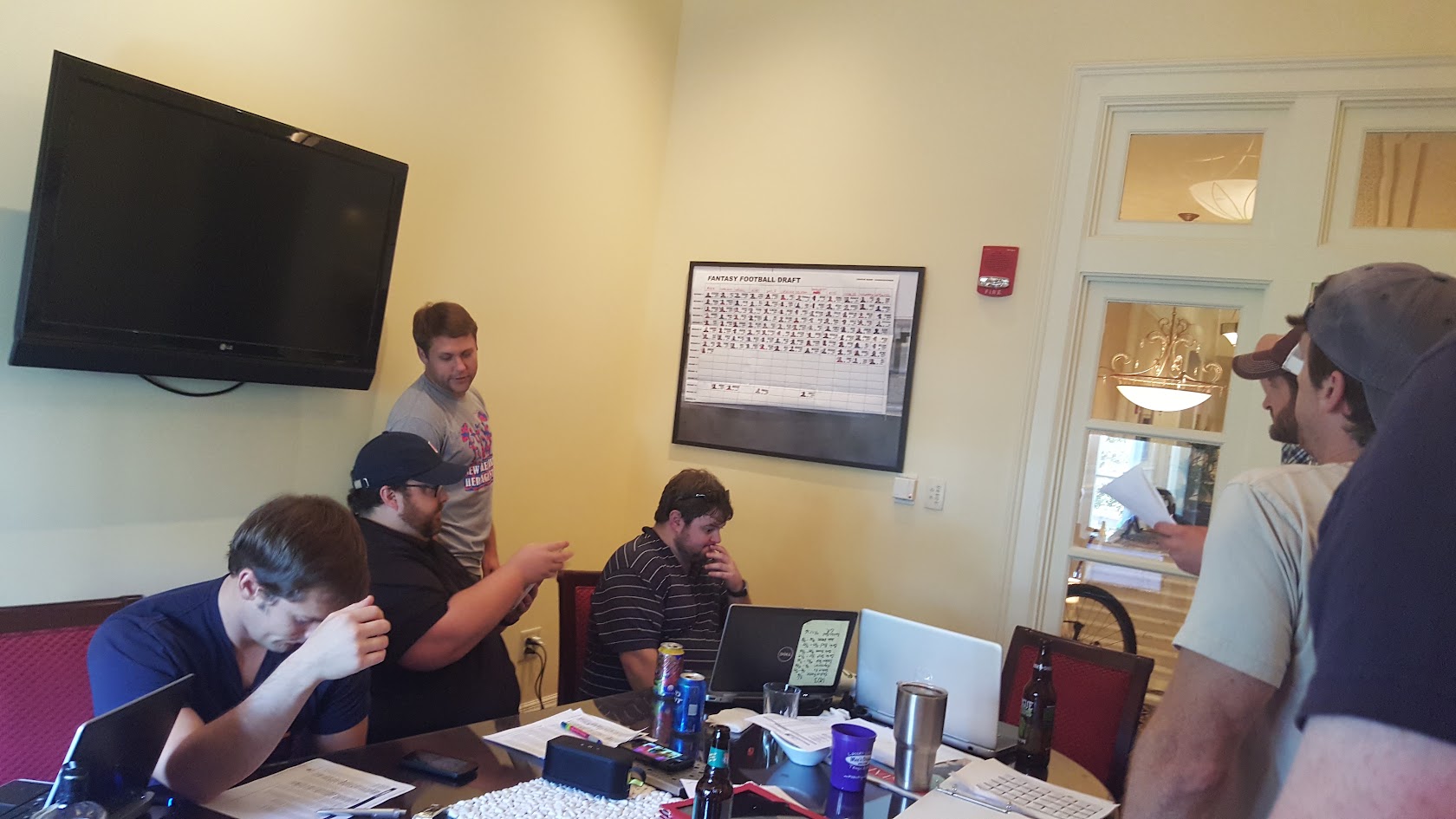 HFFL owners working through the 2015 draft around a table of laptops and draft sheets
