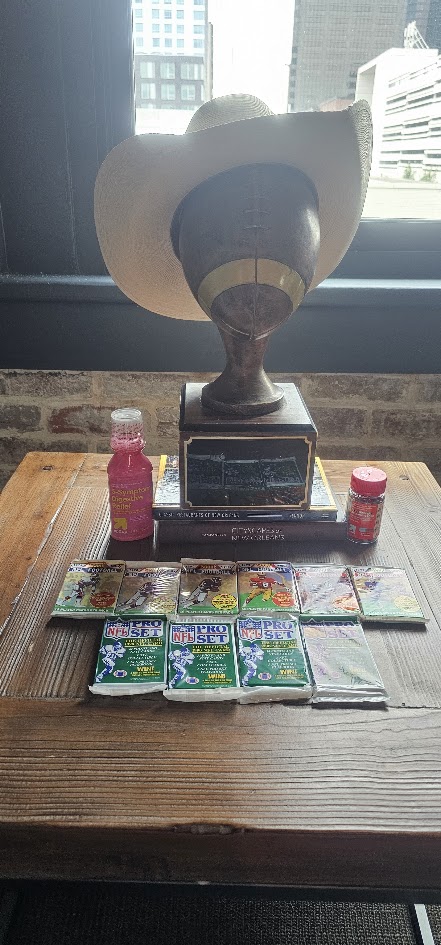 The HFFL trophy wearing a cowboy hat above draft packs and prizes